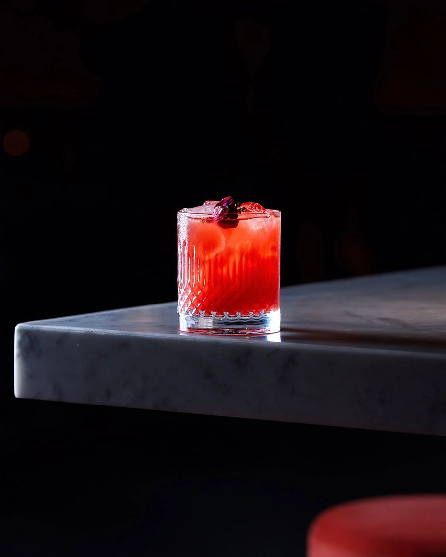 Cocktail rosso su un tavolo di marmo scuro, shooting per MAG 56
