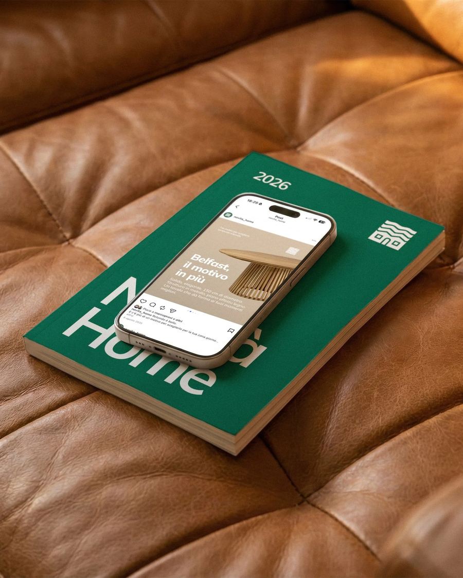 Catalogo e smartphone di Novità Home su un divano di pelle