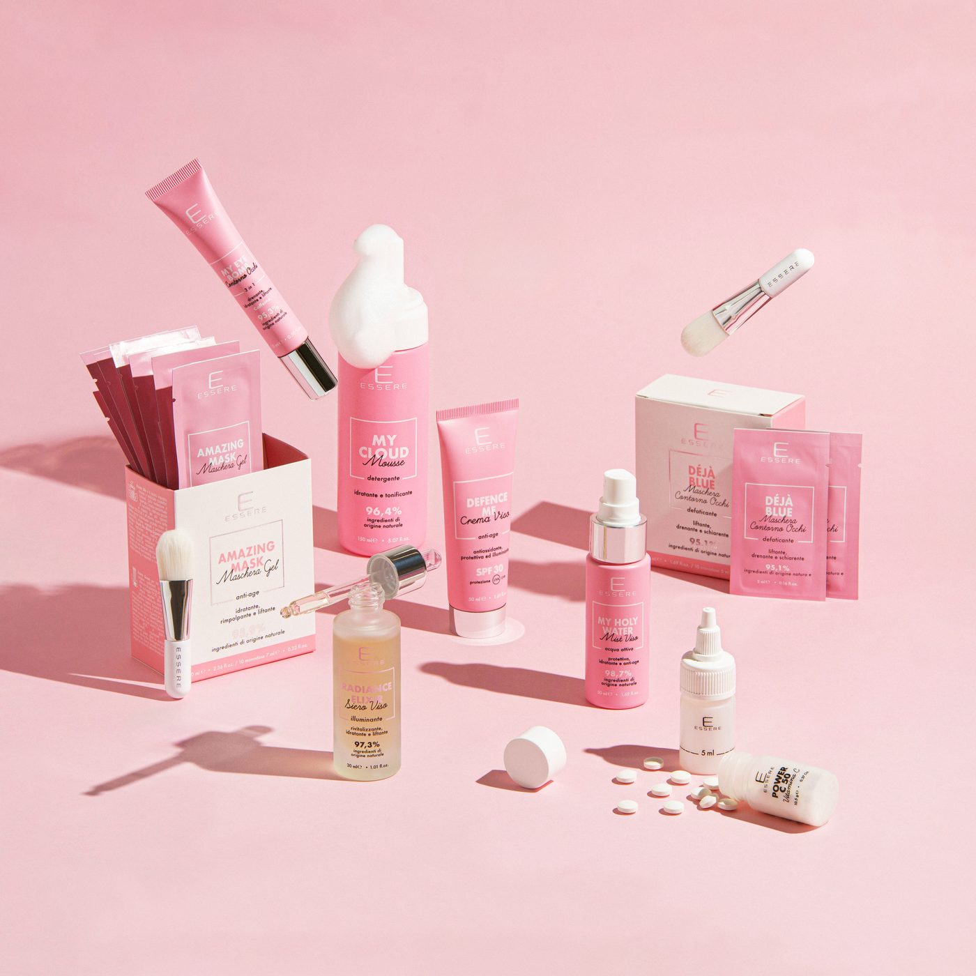 Flaconi, tubetti e confezioni Essere Bio su fondo rosa