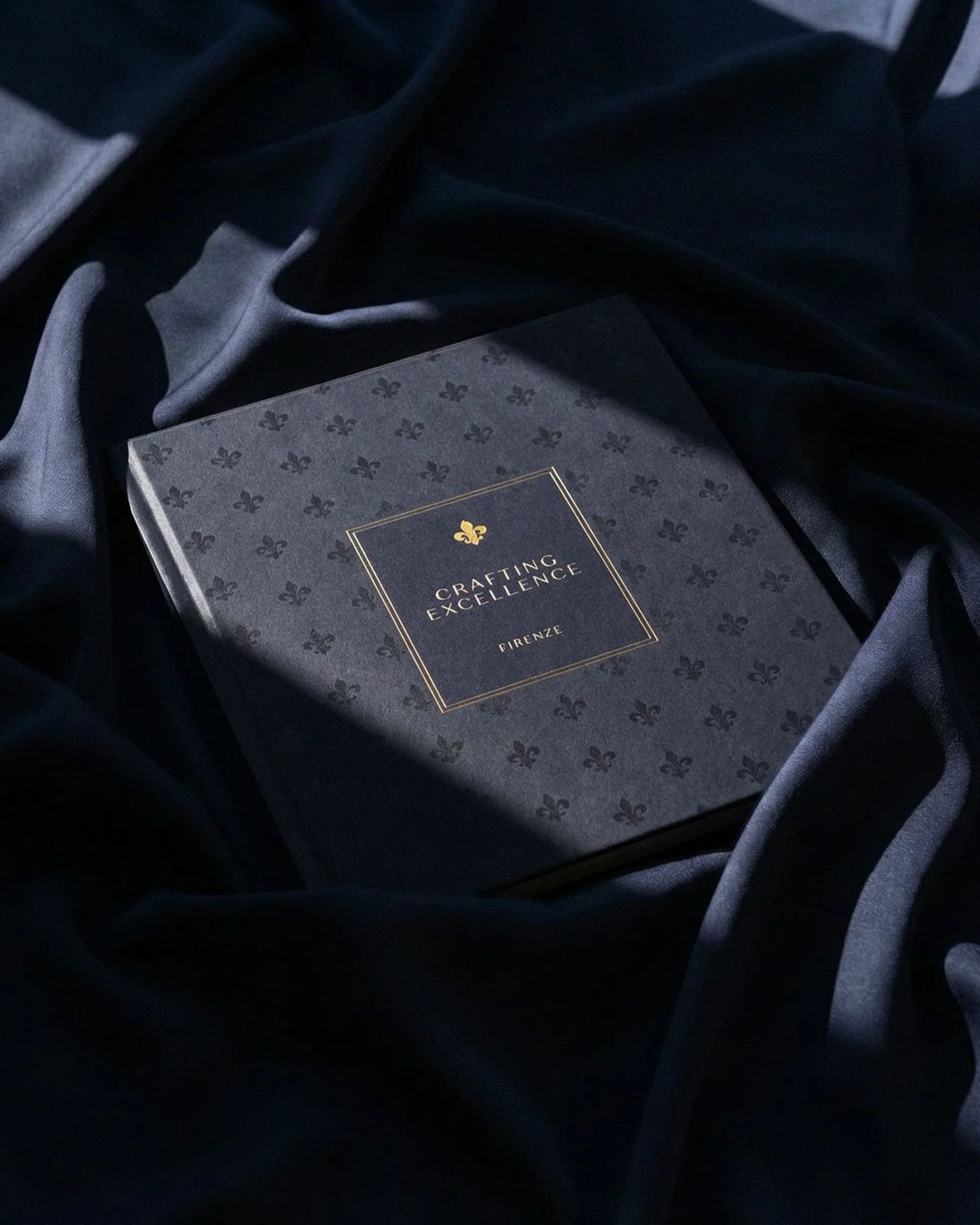 Il coffee table book Crafting Excellence. Firenze. appoggiato su un velluto blu scuro, progetto editoriale con Ruffino 1877