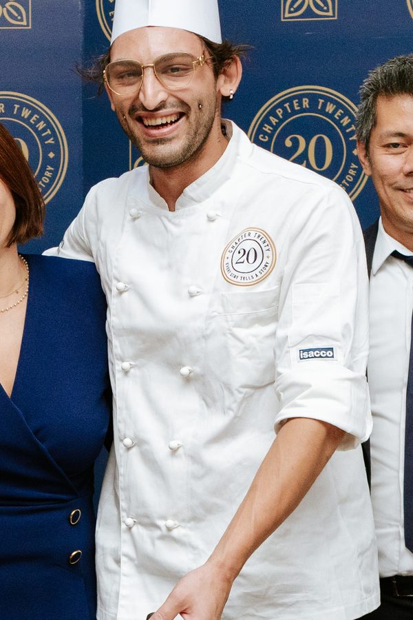 Un cuoco della serata col sigillo di Chapter 20 ricamato sulla giacca, all’altezza del cuore