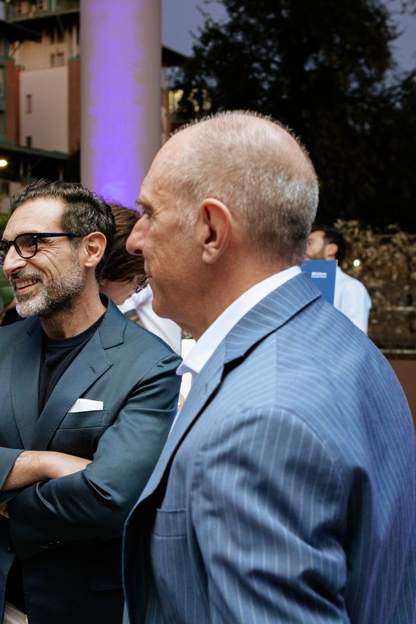 Due ospiti parlano fra loro negli spazi esterni dell’hotel