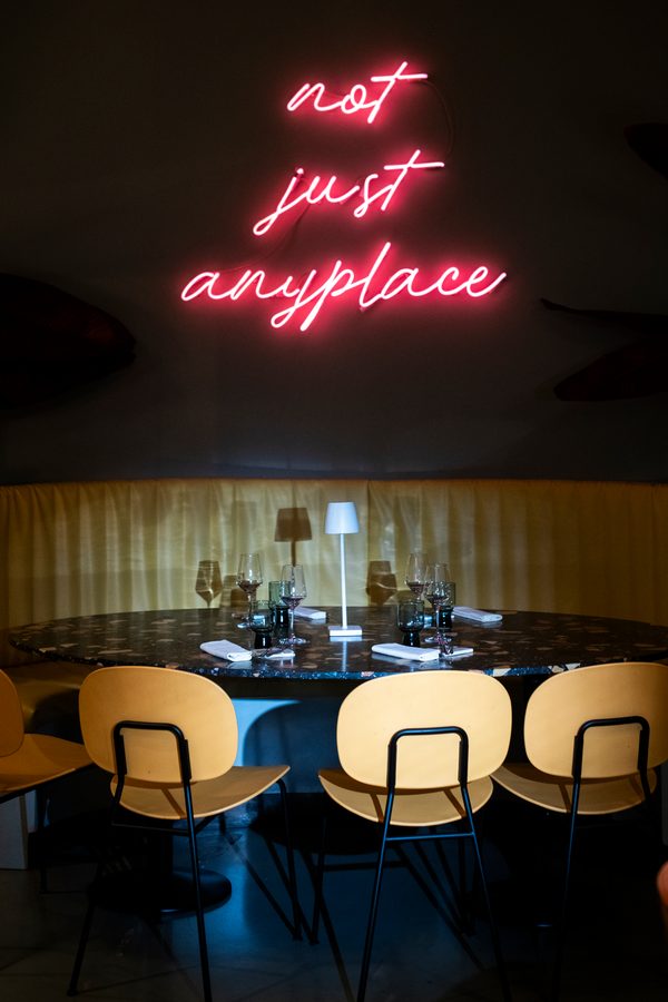 La sala di Amedeo la sera, sotto la scritta al neon