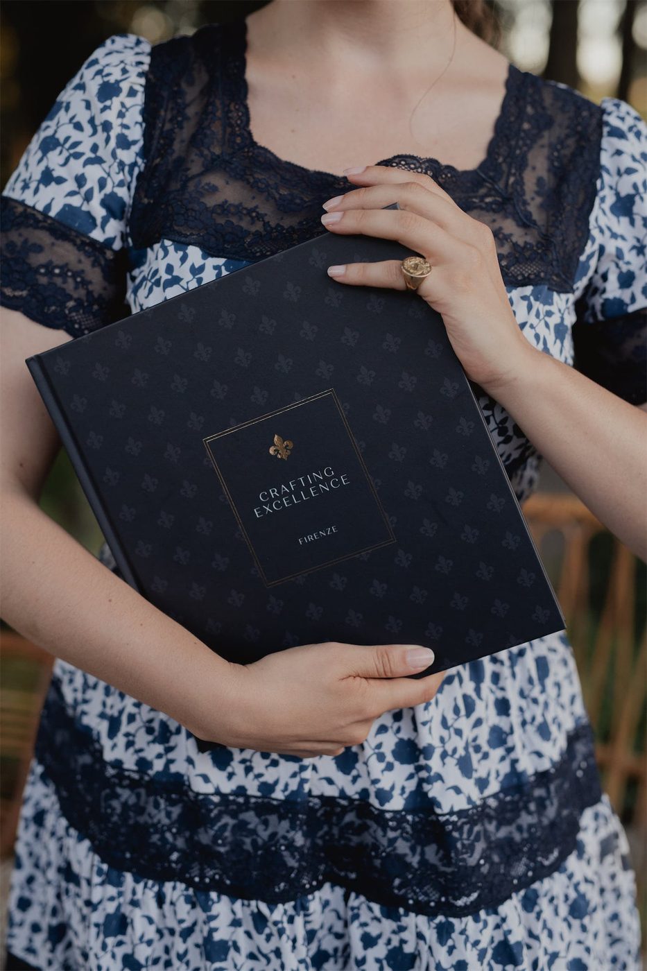 Il libro tenuto in mano davanti a un vestito a fiori blu