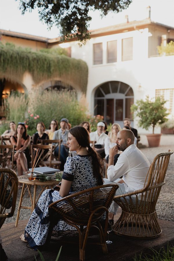 Il pubblico ascolta la presentazione davanti alla villa