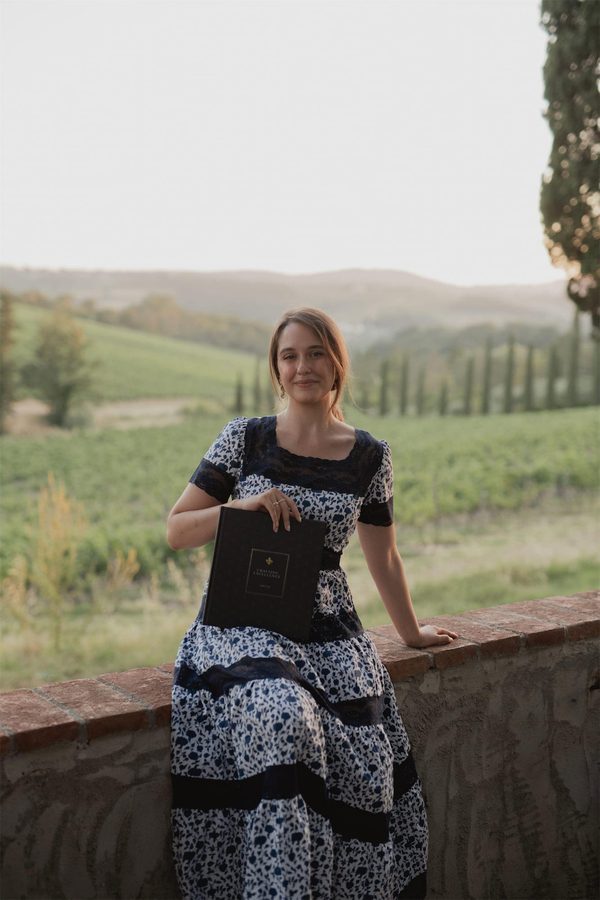 Una donna col libro sulla terrazza, davanti alle vigne
