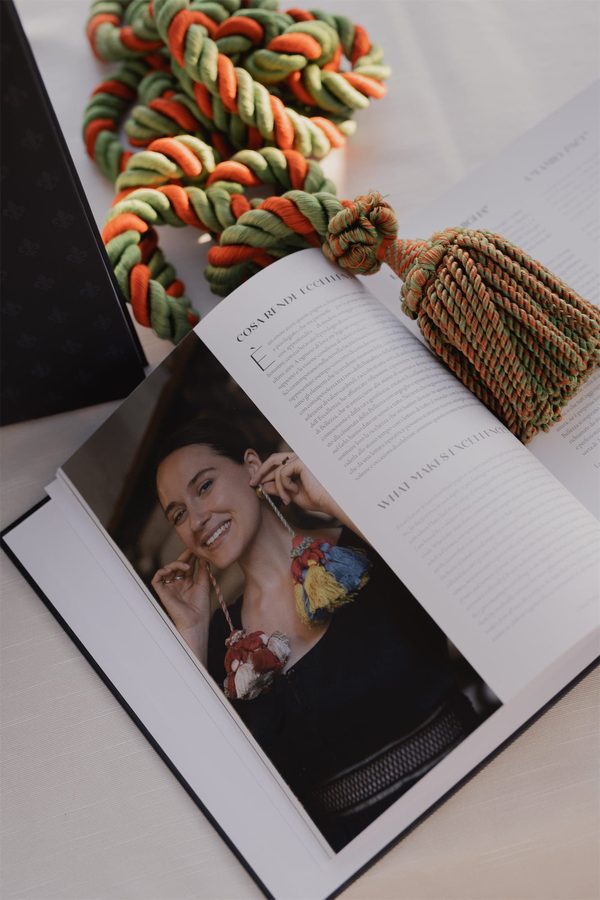 Il libro aperto su un ritratto, accanto alle nappe colorate
