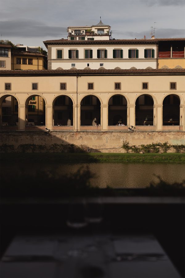 Il lungarno e i portici sull’altra riva, al tramonto