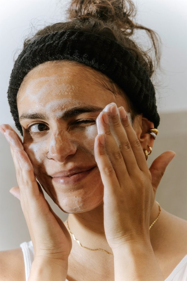 Una ragazza con la fascia nera e la maschera sul viso strizza l’occhio