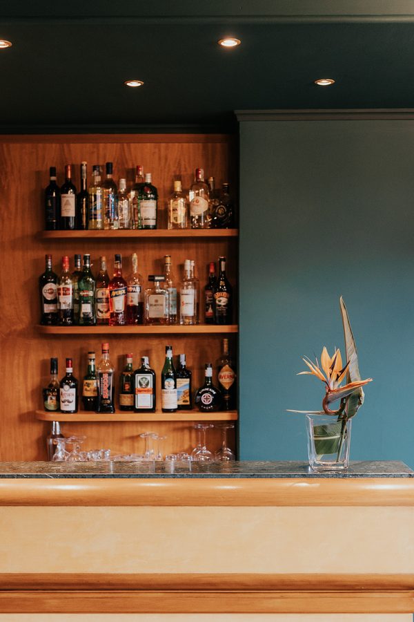 Il bancone del bar con le bottiglie sugli scaffali blu