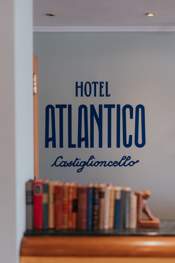 Il logo Hotel Atlantico sulla parete, sopra i libri