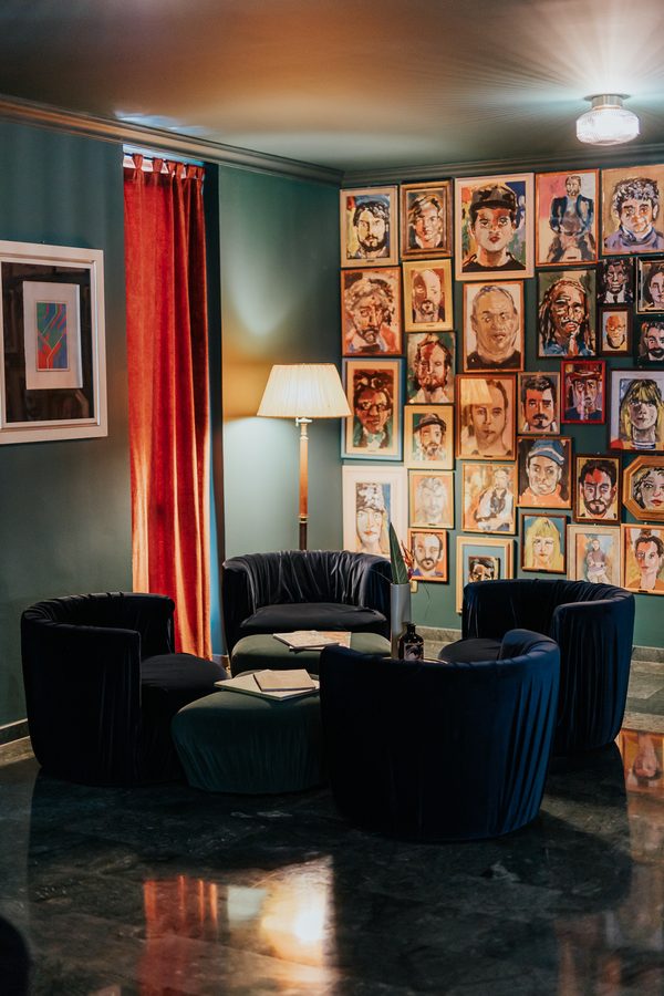 Una sala dell’hotel con le poltrone blu e le tende rosse