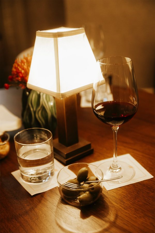 Un bicchiere di vino rosso sotto la luce di una lampada