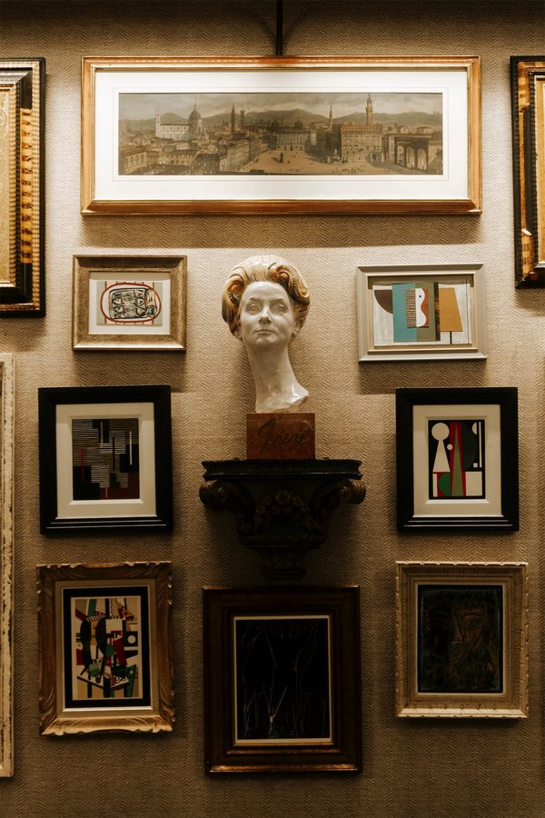 Una parete di cornici e un busto nel salone