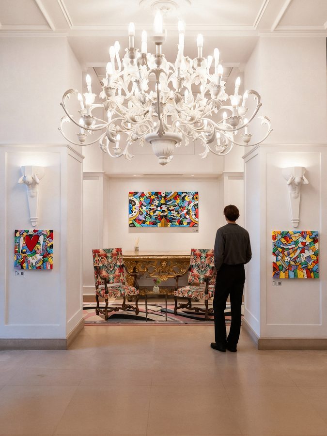 La sala col lampadario di cristallo e i quadri di SKIM alle pareti