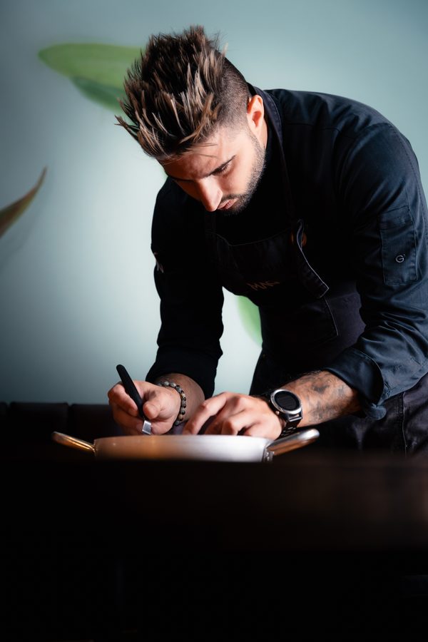 Lo chef firma un foglio sul bancone