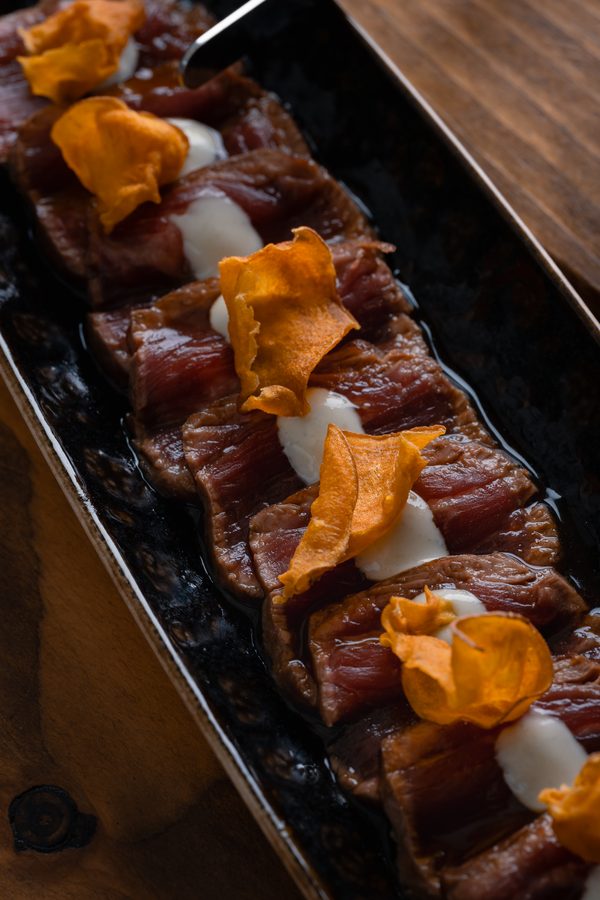 Un piatto di carne tagliata con scaglie arancioni