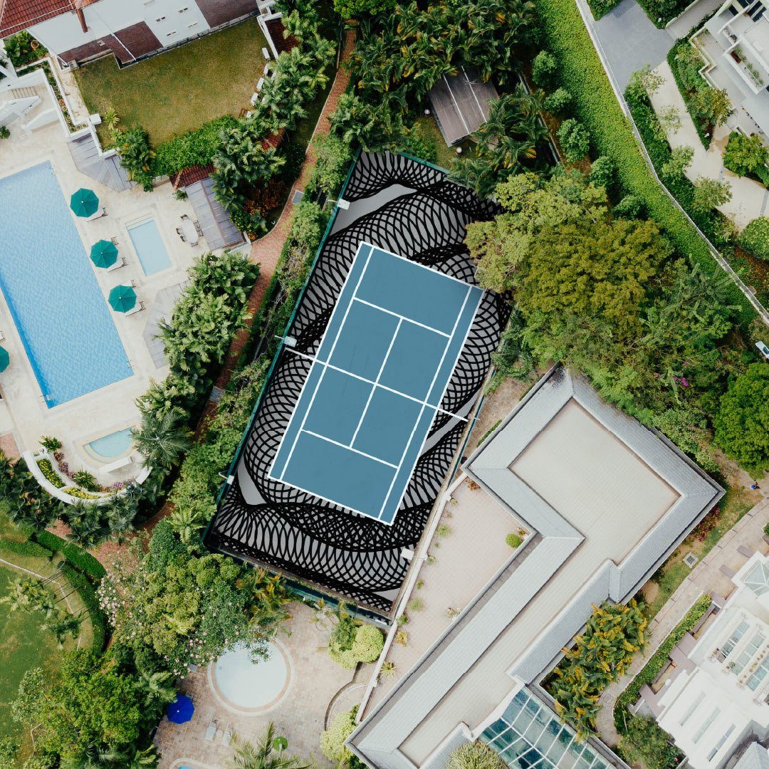 Un campo da tennis visto dall’alto fra gli alberi