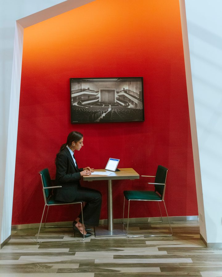 Un ospite lavora al computer davanti alla parete rossa del Mercure