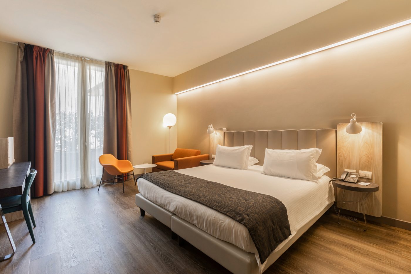 Una camera del Mercure Firenze Centro, col letto rifatto e la luce calda
