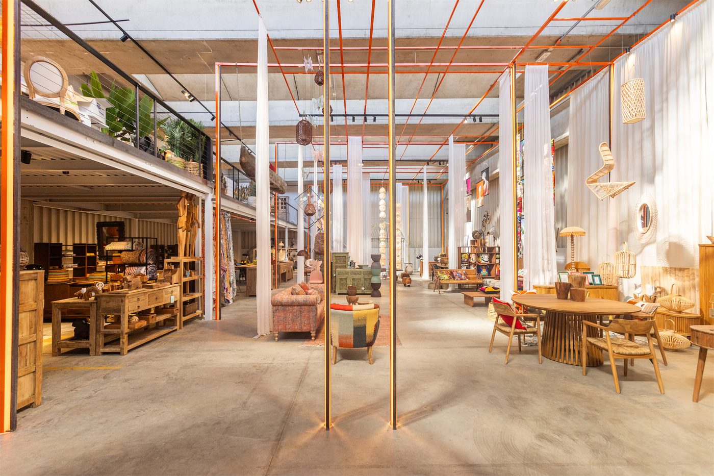 Lo showroom di Novità Home in tutta la sua lunghezza, fra tavoli e librerie