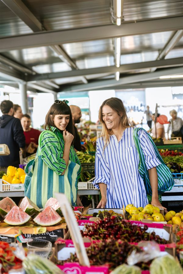 Due ragazze al mercato, una con la borsa a righe Puebco