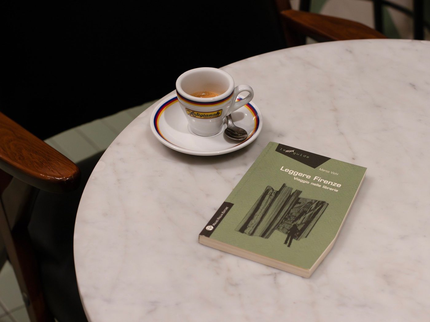Una tazza di caffè e un libro su un tavolino di marmo